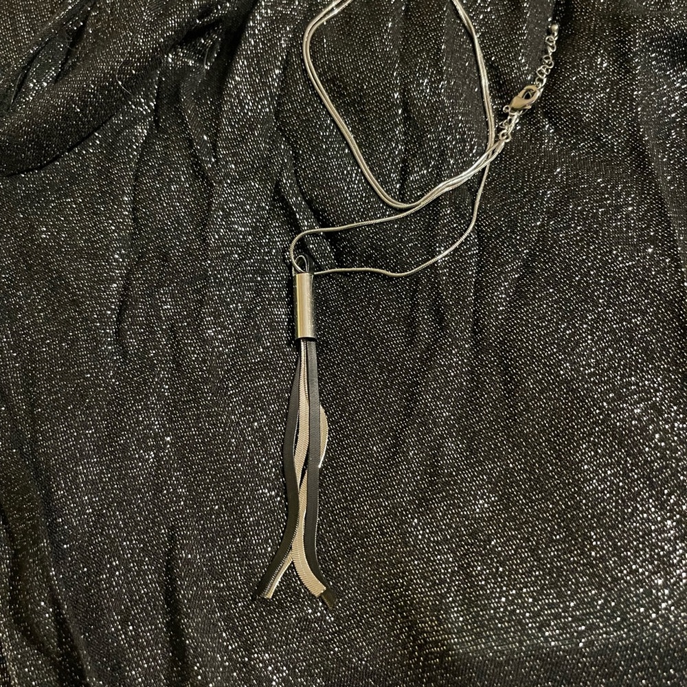 Long necklace with silver-tone and black metal tassel.